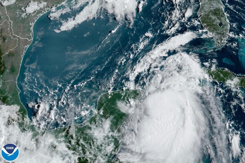 Satellite image on Aug. 28, 2023,  at 9:41 a.m. ET provided by the National Oceanic and Atmospheric Administration shows Tropical Storm Idalia moving between Mexico's Yucatan peninsula, left, and Cuba, right.