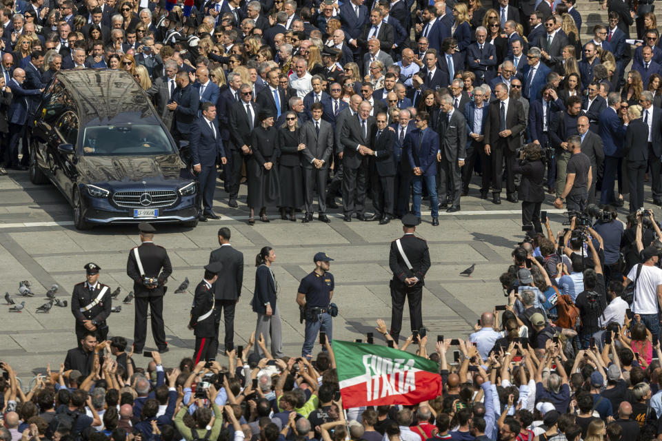 Family members of former Italian premier Silvio Berlusconi stand by the hearse carrying his casket as they acknowledge the crowd at the end of his state funeral in Milan's Duomo Gothic-era Cathedral, Italy, Wednesday, June 14, 2023. Berlusconi died at the age of 86 on Monday in a Milan hospital where he was being treated for chronic leukemia. (Stefano Porta/LaPresse via AP)