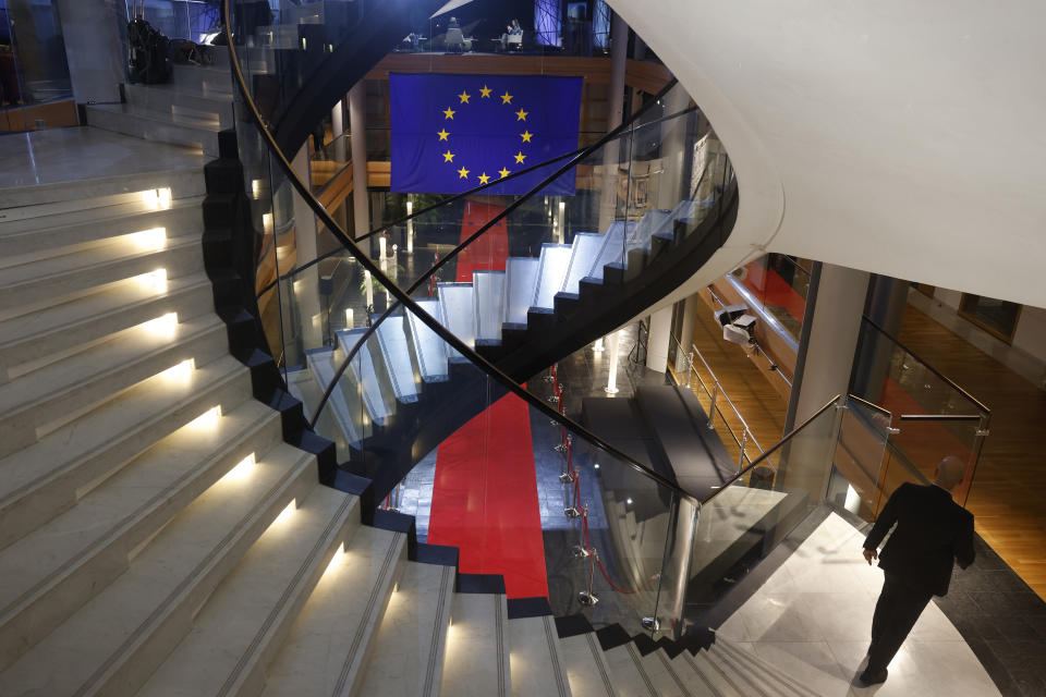 FILE - A man walks down stairs during a special session on lobbying at the European Parliament in Strasbourg, eastern France, Dec. 12, 2022. Following months of investigations, police have so far launched more than 20 raids, mostly in Belgium but also in Italy. Hundreds of thousands of euros have been found in Brussels and four people have been charged since Dec. 9 with corruption, participation in a criminal group and money laundering. (AP Photo/Jean-Francois Badias, File)