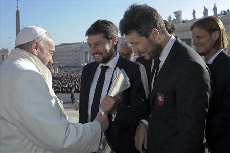 Members of Argentine soccer team San Lorenzo presents Pope Francis (L) with a replica of the Argentine soccer championship trophy during the Wednesday general audience in St Peter's Square at the Vatican December 18, 2013. REUTERS/Osservatore Romano