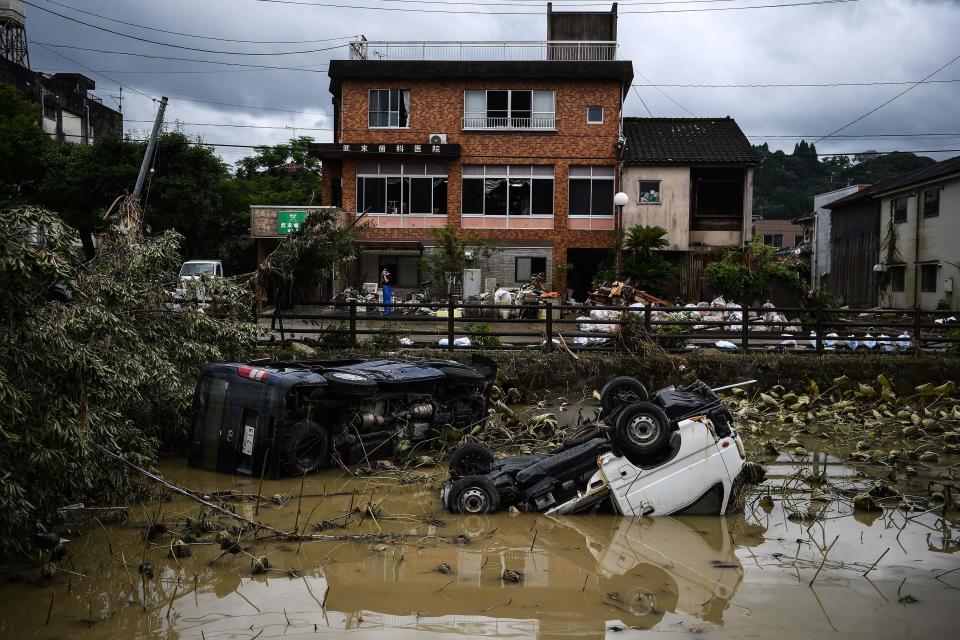 Damaged and overturned vehicles are seen in a river following heavy rains and flooding in Hitoyoshi, Kumamoto prefecture on July 9, 2020. / Credit: CHARLY TRIBALLEAU/AFP/Getty