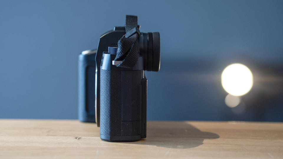 Leica SL3 camera on a wooden surface against a blue background