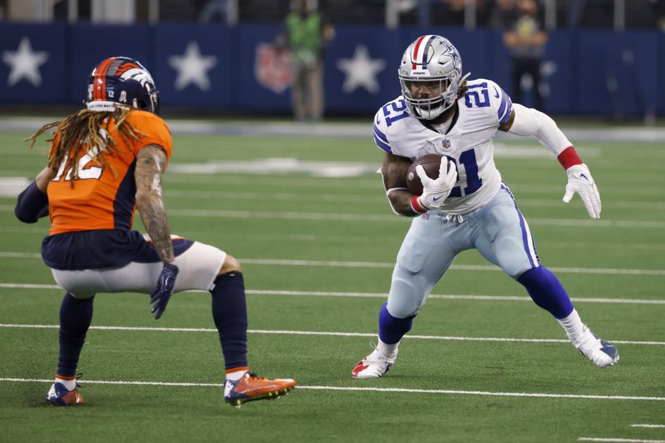 Denver Broncos cornerback Mike Ford, left, defends as Dallas Cowboys running back Ezekiel Elliott (21) looks for running room in the second half of an NFL football game in Arlington, Texas, Sunday, Nov. 7, 2021. (AP Photo/Ron Jenkins)