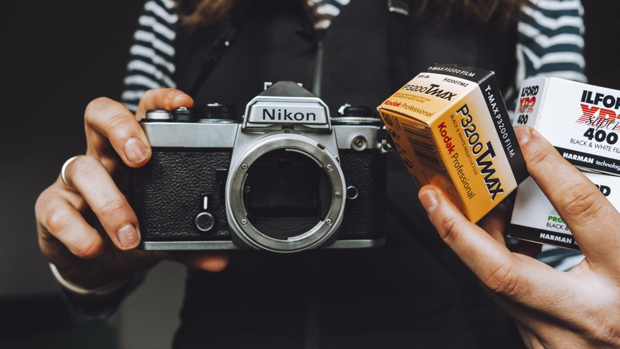  The Nikon FE film camera and three boxes of 35mm film. 