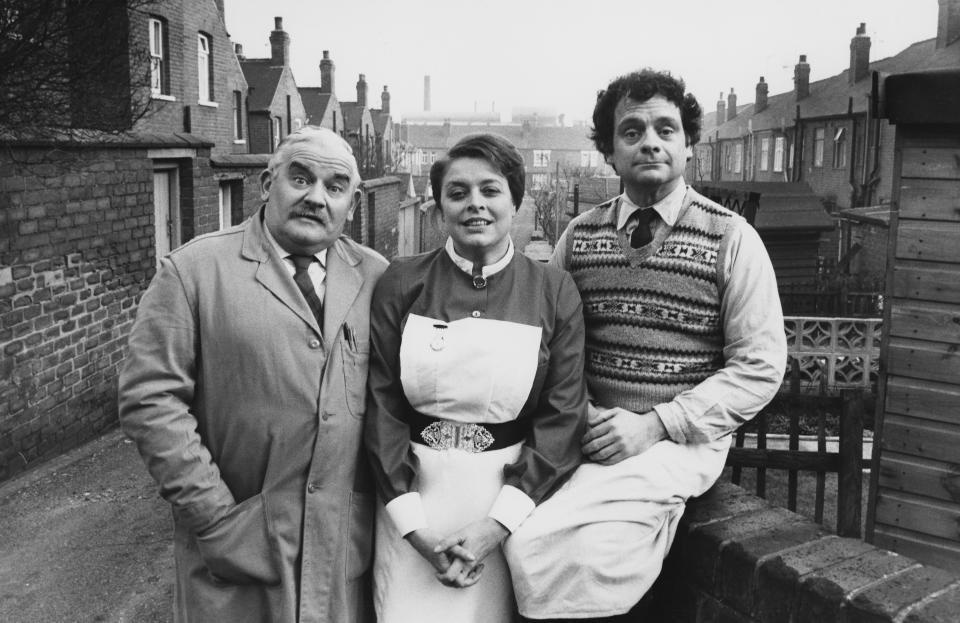 Portrait of actors (L-R) Ronnie Barker, Lynda Baron and David Jason standing in a back alley, photographed for Radio Times in connection with the television sitcom 'Open All Hours', South Yorkshire, January 30th 1981. (Photo by Don Smith/Radio Times/Getty Images)