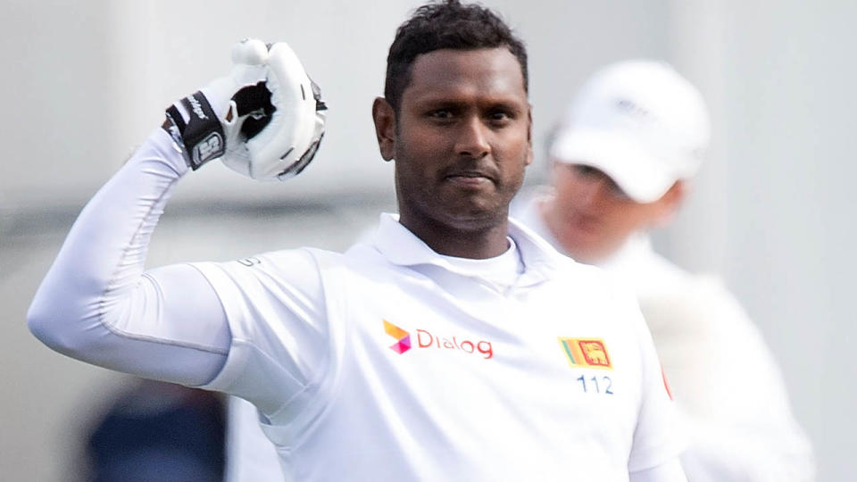 Angelo Mathews celebrates reaching his century. (Photo by MARTY MELVILLE/AFP/Getty Images)