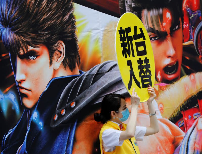 A woman wearing a protective face mask attracts to customers on the street amid the coronavirus disease (COVID-19) outbreak, in Tokyo