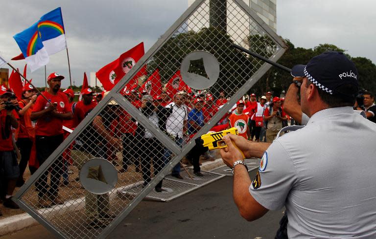 Members of the Landless Rural Workers Movement clash with policemen during a protest in Brasilia, on February 12, 2014