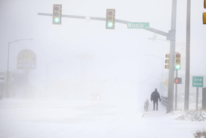 James Little crosses the street during a blizzard on Wednesday, March 13, 2019, in Cheyenne, Wyo. Heavy snow hit Cheyenne about mid-morning Wednesday and was spreading into Colorado and Nebraska. (Jacob Byk/The Wyoming Tribune Eagle via AP)