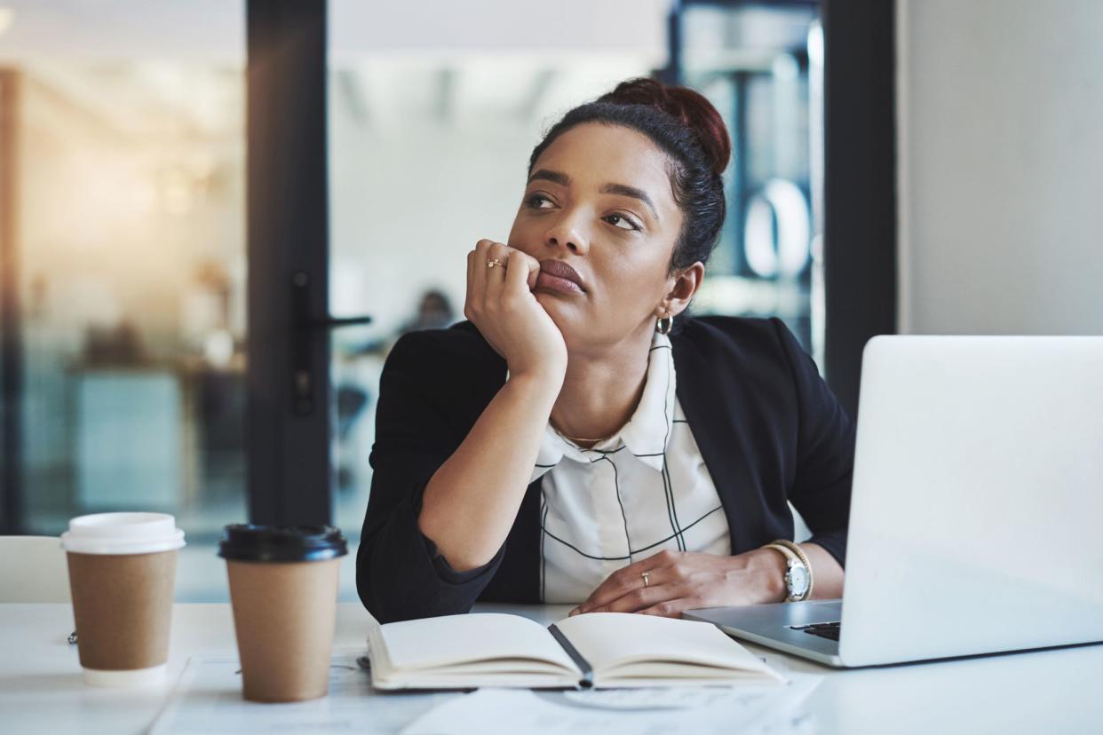 Shot of a young businesswoman looking bored while working at her desk in a modern office