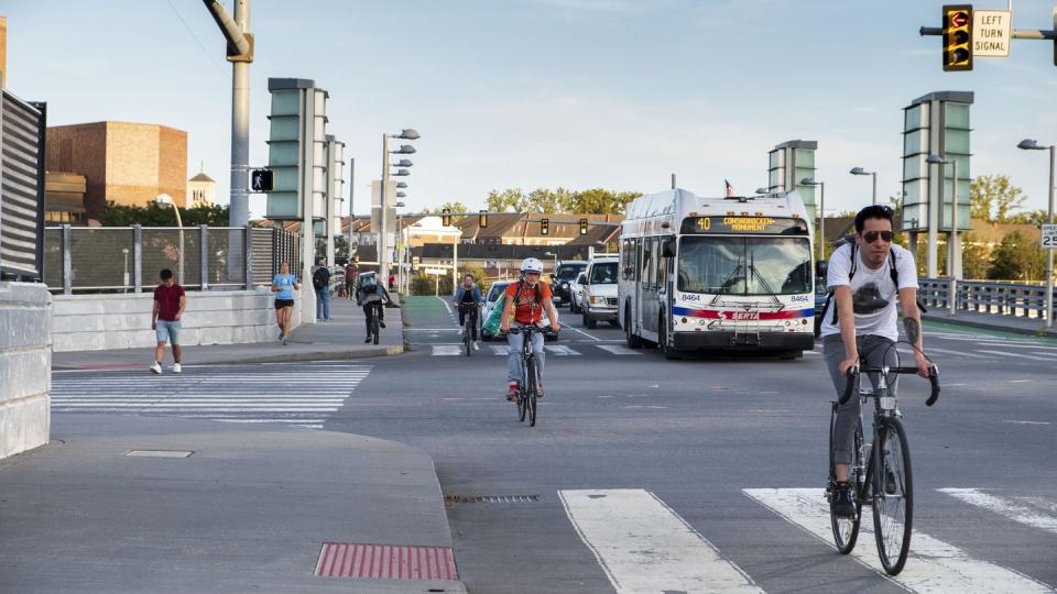 cyclists commuting on city streets bike lanes with cars and traffic, university city, philadelphia, pennsylvania, usa