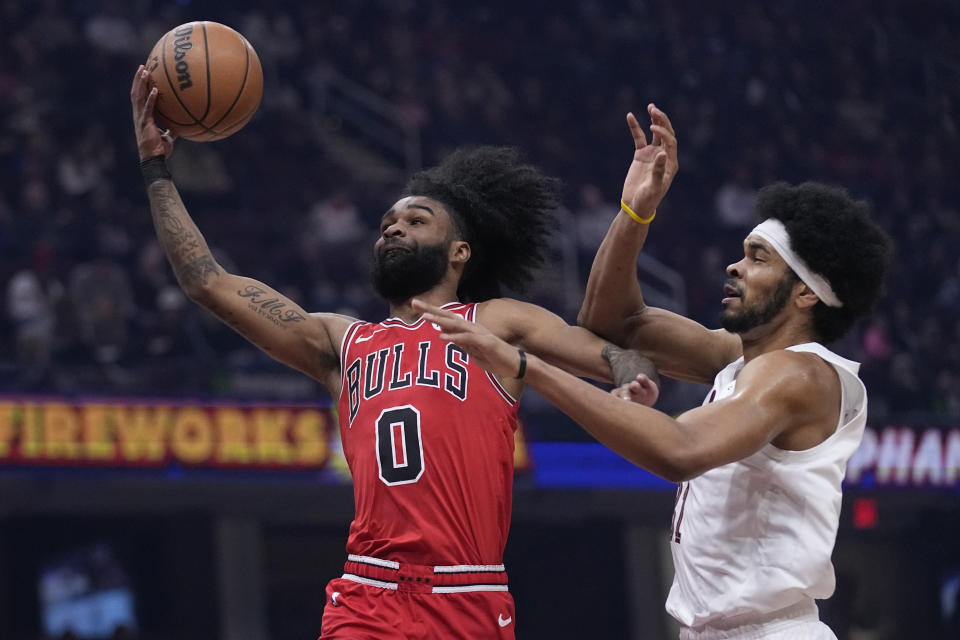 Chicago Bulls guard Coby White (0) goes to the basket past Cleveland Cavaliers center Jarrett Allen, right, in the first half of an NBA basketball game, Monday, Jan. 15, 2024, in Cleveland. (AP Photo/Sue Ogrocki)