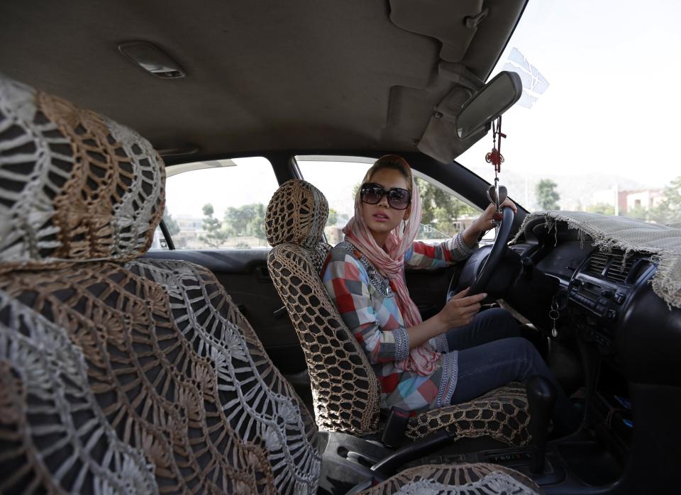 Kanaz listens to her instructor during a practical driving test in Kabul