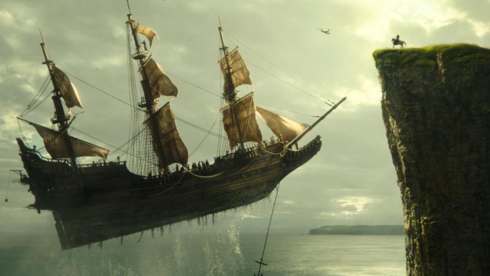 a large ship floats in the sky towards a cliff in peter pan & wendy 