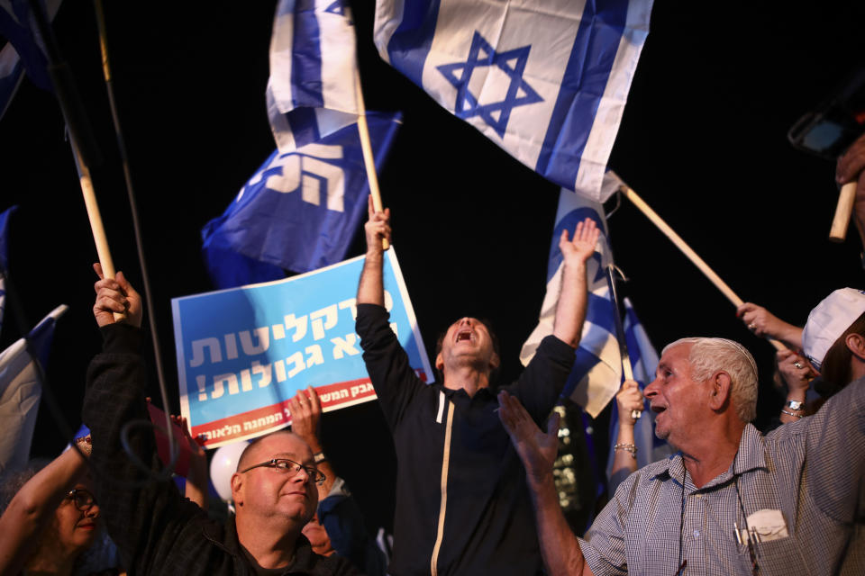 Israeli Prime Minister supporters cheerduring a support rally in Tel Aviv, Israel, Tuesday, Nov. 26, 2019. The sign with Hebrew reads: " Attorney's office is without borders."(AP Photo/Oded Balilty)