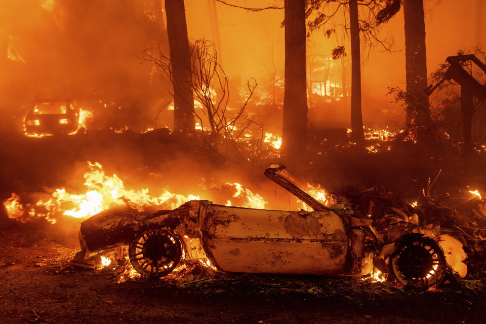 Flames consume vehicles as the Dixie Fire tears through the Indian Falls community in Plumas County, Calif., Saturday, July 24, 2021. The fire destroyed multiple residences in the area. (AP Photo/Noah Berger)