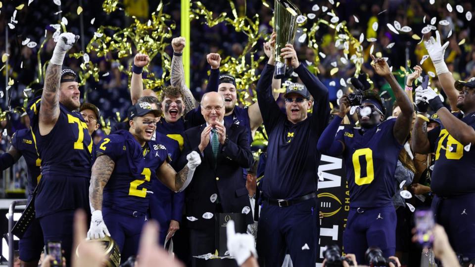 Head coach Jim Harbaugh of the Michigan Wolverines and his team react as he lifts the national championship trophy after defeating the Washington Huskies during the 2024 CFP National Championship game at NRG Stadium on January 08, 2024 in Houston, Texas.  (Maddie Meyer/Getty Images)