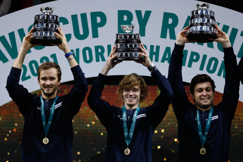 Russian players Daniil Medvedev, Andrey Rublev and Aslan Karatsev pose for a trophy after winning the Davis Cup Finals 2021.