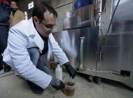 Christofer Costes, a French inventor who created a machine that turns plastic waste into fuel, collects gas from his invention in Puget-Theniers, France, December 14, 2018. Picture taken December 14, 2018. REUTERS/Eric Gaillard