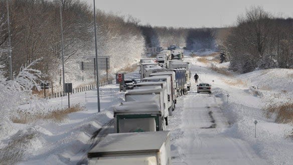 A section of westbound Highway 402 near Sarnia, Ont., was closed in 2010 as crews worked to dig out trucks and cars from a snow storm.  ((Glenn Ogilvie/Canadian Press) - image credit)