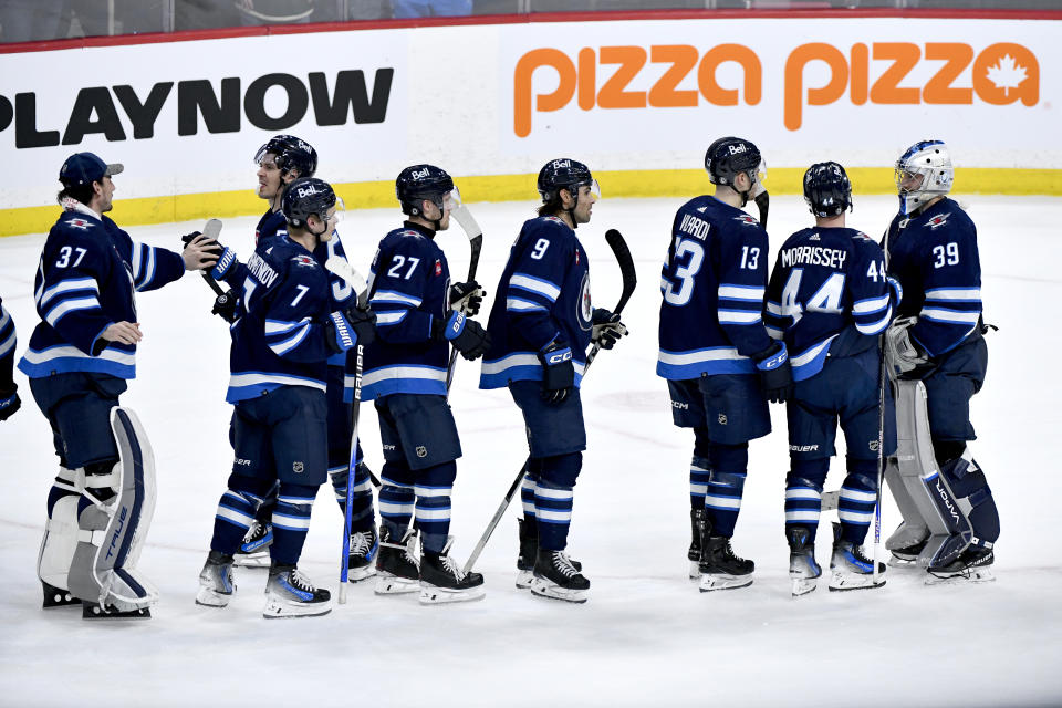 Winnipeg Jets goaltender Laurent Brossoit (39) and teammates celebrate a win against the Minnesota Wild in an NHL hockey game Tuesday, Feb. 20, 2024, in Winnipeg, Manitoba. (Fred Greenslade/The Canadian Press via AP)