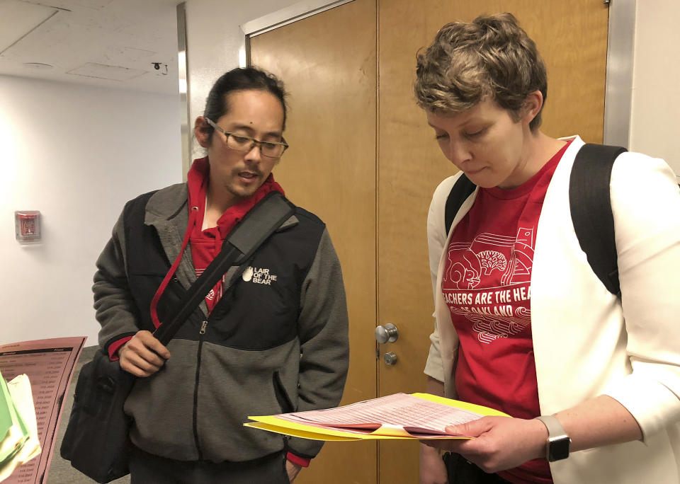 Cliff Hong, a principal at Roosevelt Middle School, left, and Amie Lamontagne, a principal at Fred T. Korematsu Discovery Academy, discuss their schedule for meeting with California lawmakers about Oakland school funding during a visit to the Capitol in Sacramento, Calif., Wednesday, Feb. 20, 2019. The principals are not striking but support better pay for teachers. Teachers in Oakland, Calif., prepared Wednesday to walk off the job in what could be the nation's latest strike over classroom conditions and pay. (AP Photo/Kathleen Ronayne)