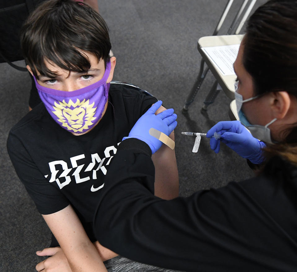 Liam McAteer, de 14 años, es vacunado contra el covid-19 con el fármaco de Pfizer en Florida. (Getty Images)