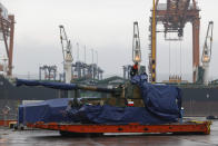 A worker uncovers South Korean Thunder K9 howitzer in the Polish Navy port of Gdynia, Poland, Tuesday, Dec. 6, 2022. Poland's President Andrzej Duda and the defense minister on Tuesday welcomed the first delivery of tanks and howitzers from South Korea, hailing the swift implementation of a deal signed in the summer in the face of the war in neighbouring Ukraine. (AP Photo/Michal Dyjuk)