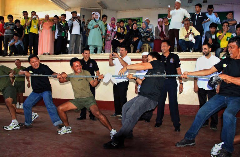 This file photo, taken on October 28, 2012, shows Philippine government troops (green shirts) join in a tug-of-war with Moro Islamic Liberation Front (MILF) rebels (black shirts) in Marawi, on the southern Philippine island of Mindanao, as part of a Thanksgiving Day ceremony to mark the signing of the Bangsamoro Framework Agreement