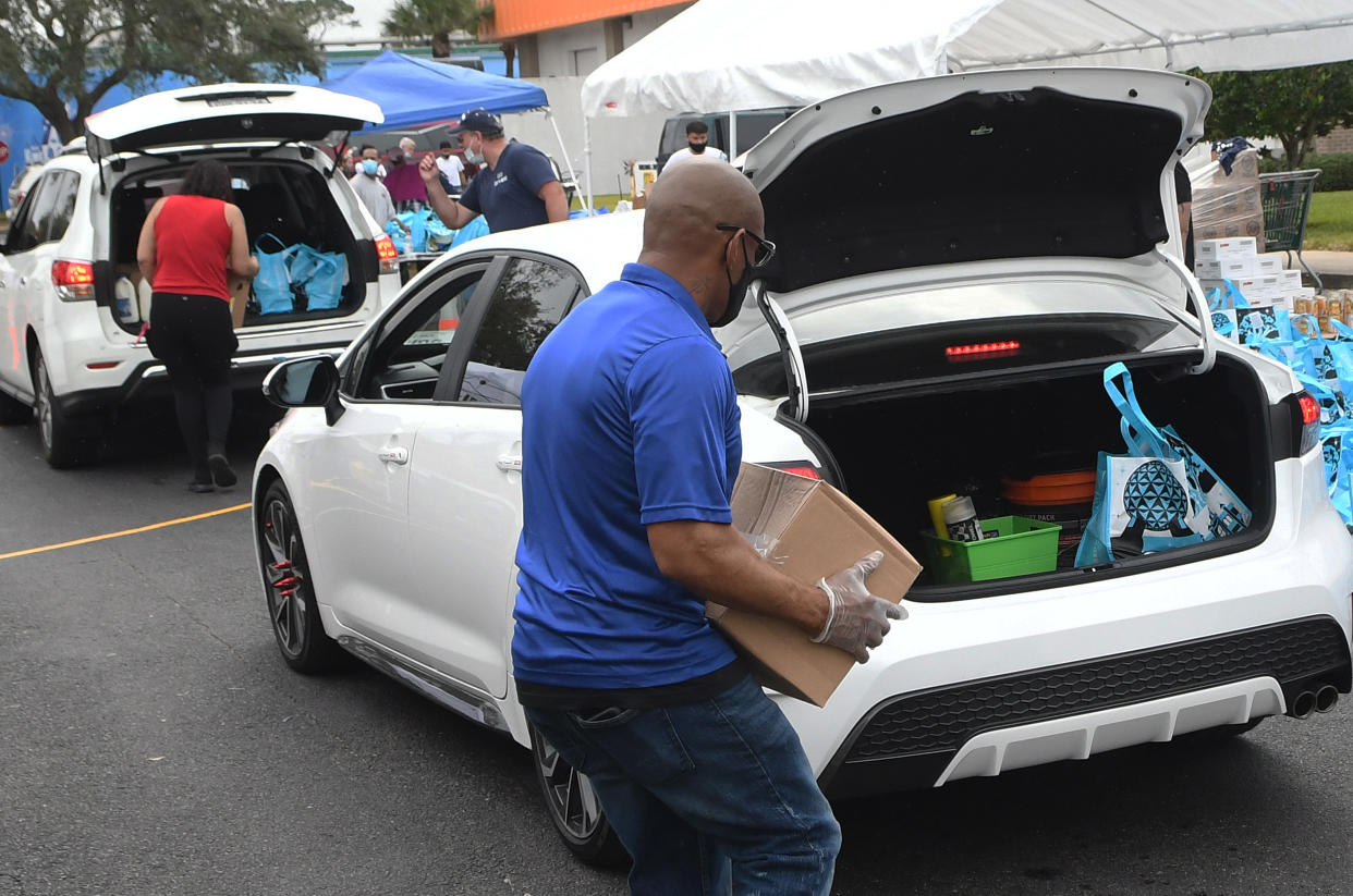 Volunteers load cars with turkeys and other food assistance for laid off Walt Disney World cast members and others at a food distribution event on December 12, 2020 in Orlando, Florida. Tom and Sarah Bricker, a couple who runs the Disney Tourist Blog, raised over $64,000 in on-line donations for the Second Harvest Food Bank of Central Florida, which partnered with Good Samaritan Outreach to help the unemployed theme park workers. (Photo by Paul Hennessy/NurPhoto via Getty Images)