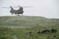 A Chinook helicopter flies over a field during a joint military drill between Japan Self-Defense Force, French army and U.S. Marines, at the Kirishima exercise area in Ebino, Miyazaki prefecture, southern Japan Saturday, May 15, 2021. (Charly Triballeau/Pool Photo via AP)