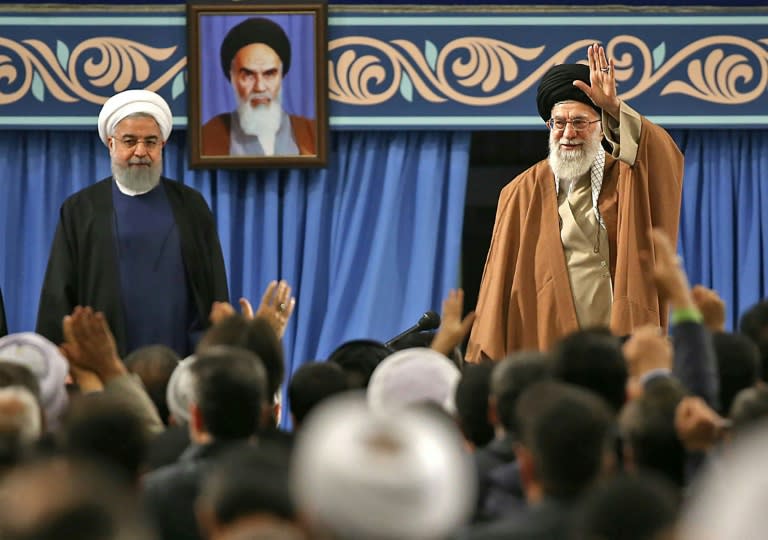 Iran's supreme leader Ayatollah Ali Khamenei waves next to President Hassan Rouhani (L) during a meeting in Tehran on December 6, 2017