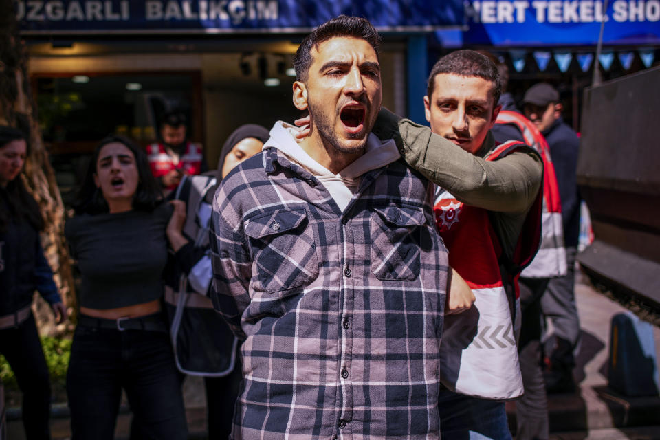 People are detained as they march with other union members during Labor day celebrations in Istanbul, Turkey, Monday, May 1, 2023. As in previous years, police in Turkey prevented a group of demonstrators from reaching Istanbul's main square Taksim, and detained around a dozen protesters. Journalists trying to film demonstrators being forcibly moved into police vans, were also pushed back or detained. (AP Photo/Emrah Gurel)