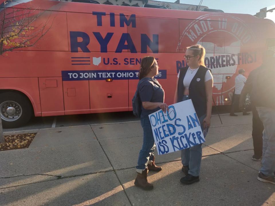 Fans of Democratic Ohio Senate hopeful Rep. Tim Ryan chat in front of his campaign bus during a rally in Xenia, Ohio on November 4, 2022.