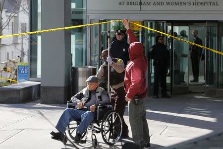 A man in wheelchair is taken away from the building where a shooting occurred at Brigham and Women's hospital in Boston, Massachusetts January 20, 2015. REUTERS/Brian Snyder