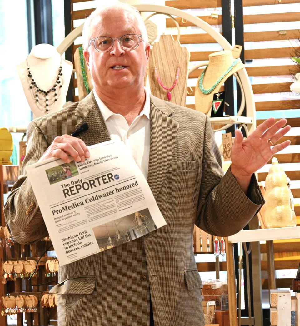 Alan Sattler, president of ProMedica Coldwater holding up a Daily Reporter with the May story announcing its Leapfrog safety ranking during the July Realtor breakfast.