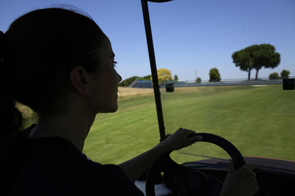 Lara Arias, a rare female golf course superintendent, drives a golf cart during an interview with the Associated Press, at the Marco Simone Club in Guidonia Montecelio, Italy, Tuesday, July 11, 2023. When Lara Arias started her job as course superintendent at the Marco Simone golf club outside Rome that will host the Ryder Cup from Sept. 29 to Oct.1 there was hardly any grass to manicure, no bunkers to rake and nary a green to shape, the entire course was practically one big pile of dirt amid a complete restyling. (AP Photo/Alessandra Tarantino)