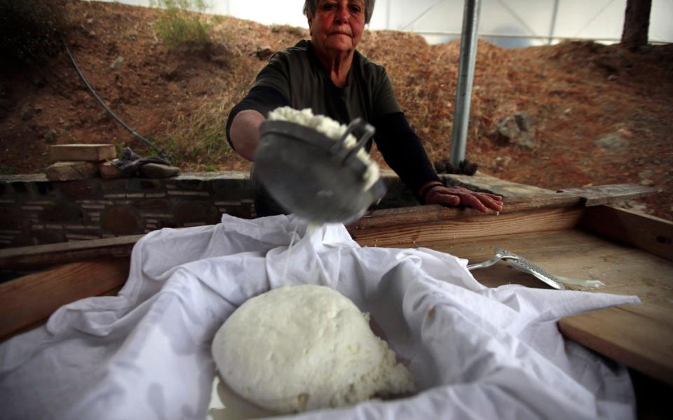 A woman makes halloumi on a farm near Nicosia, the island's divided capital  - Petros Karadjias /AP