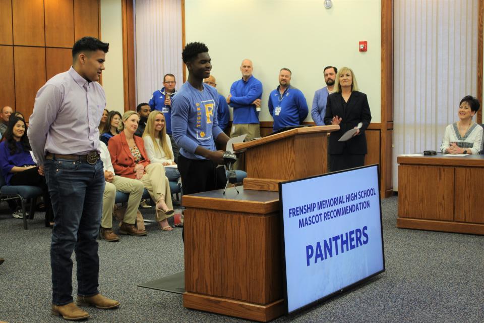Frenship ISD eighth-graders David Valdez, left, and Ben Trevey, center, present Memorial High School mascot and school color recommendations to the Frenship school board as Superintendent Michelle McCord applauds during a meeting Thursday morning in Wolfforth.