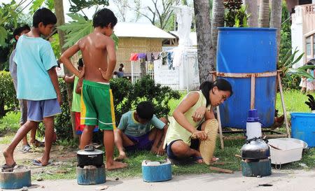 Residents cook their meals on higher ground after evacuating their homes due to super-typhoon Hagupit in Tacloban city, central Philippines December 5, 2014. REUTERS/Rowel Montes