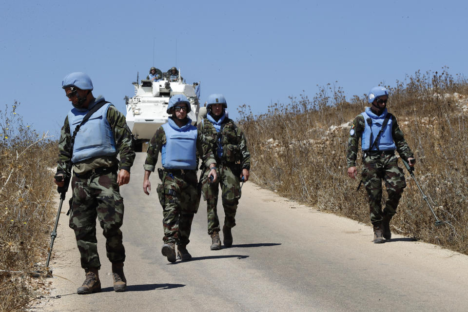 Irish UN peacekeepers use mine detectors as they patrol near the fields struck by Israeli army shells in the southern Lebanese-Israeli border village of Maroun el-Ras, Lebanon, Monday, Sept. 2, 2019. The Lebanon-Israel border was mostly calm with U.N. peacekeepers patrolling the border Monday, a day after the Lebanese militant Hezbollah group fired a barrage of anti-tank missiles into Israel, triggering Israeli artillery fire that lasted less than two hours and caused some fires. (AP Photo/Hussein Malla)