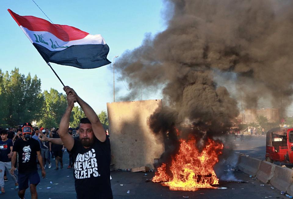 Anti-government protesters set fires and close a street during a demonstration in Baghdad, Iraq, Friday, Oct. 4, 2019. Security forces opened fire directly at hundreds of anti-government demonstrators in central Baghdad, killing some protesters and injuring dozens, hours after Iraq's top Shiite cleric warned both sides to end four days of violence "before it's too late." (AP Photo/Khalid Mohammed)