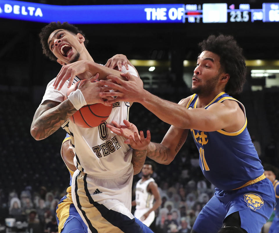 Georgia Tech guard Michael Devoe, left, holds onto a rebound against Pittsburgh defender Justin Champagnie in the final minutes of an NCAA college basketball game in Atlanta, Sunday, Feb 14, 2021. Georgia Tech beat Pittsburgh 71-65. (Curtis Compton/Atlanta Journal-Constitution via AP)