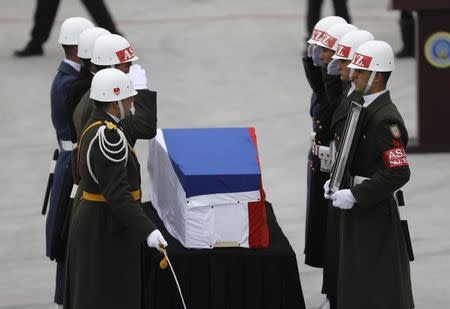 Honor guards salute next to the flag-wrapped coffin of late Russian Ambassador to Turkey Andrei Karlov during a ceremony at Esenboga airport in Ankara, Turkey, December 20, 2016. REUTERS/Umit Bektas