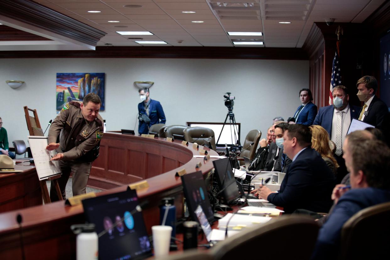 South Dakota Highway Patrol Sgt. Kevin Kinney, left, points to a diagram of the 2020 crash in which South Dakota Attorney General Jason Ravnsborg struck and killed a man walking near a rural highway,  during a House impeachment investigative committee meeting in Pierre, S.D., on Tuesday, Jan. 18, 2022. Lawmakers are weighing whether Ravnsborg should face impeachment charges. (AP Photo/Stephen Groves)