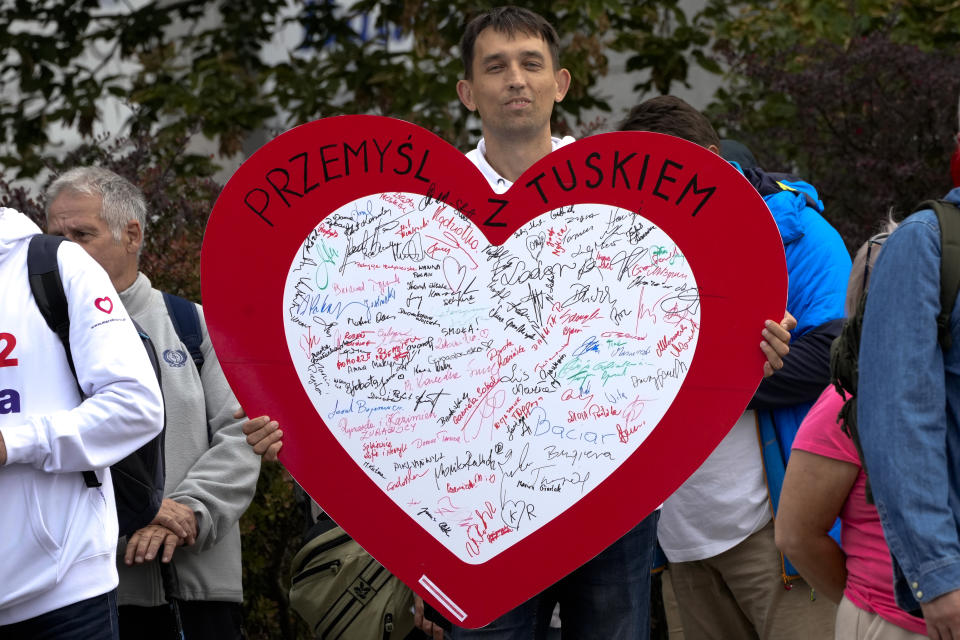 A man shows a big heart with signatures and the slogan "Industry for Tusk" during a march to support the opposition against the governing populist Law and Justice party in Warsaw, Poland, Sunday, Oct. 1, 2023. Polish opposition leader Donald Tusk seeks to boost his election chances for the parliament elections on Oct. 15, 2023, leading the rally in the Polish capital. (AP Photo/Rafal Oleksiewicz)