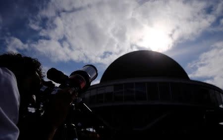 A man uses a telescope to observe the planet Mercury transit in front of the sun outside Buenos Aires' planetarium, Argentina, May 9, 2016. REUTERS/Marcos Brindicci