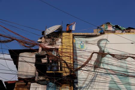 Electric wires are seen as a boy plays on the rooftop of Vitas Tenement, a government housing building, in Tondo, Manila, Philippines, May 8, 2018. REUTERS/Erik De Castro