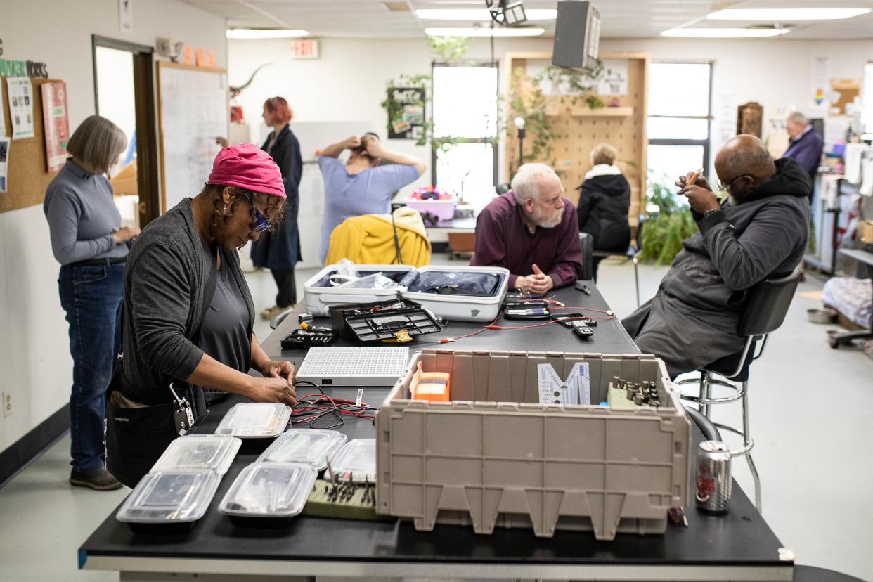 Mona Peacewalker, of Romulus, left, uses the tools provided to try to repair a light panel as Makers Works staff member Randy Williams, right, helps repair an alarm clock with a broken hinge during Fix-It Friday at Maker Works in Ann Arbor on Friday, April 19, 2024.