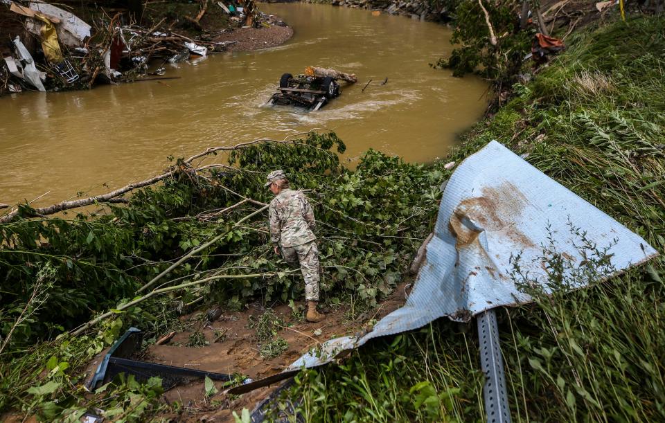 A Kentucky National Guard soldier looks through debris near Troublesome Creek for flood victims in Fisty, Ky. Saturday morning. At least two people died after being swept away by flood waters and others feared missing from the small Knott County hamlet. One resident, Cody Thompson, said his grandmother and father are missing and people were hanging onto his home's gutters from the second floor as surging storm waters rushed through the area.  July 30, 2022